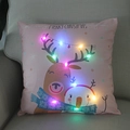 Detail of pink Christmas pillow with reindeer and glowing LED lights on beige sofa - Pink Reindeer & Snowman-21M-27