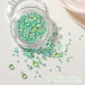 Dettaglio macro di perle di vetro aurora sirena di dimensioni miste su superficie bianca - Verde Frutta Mocha