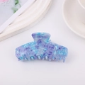 Dettaglio del mollettone per capelli in acetato marmorizzato blu con finitura lucida - Verde petrolio