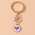 Llavero dorado con dijes de corazón blancos y colgante redondo con corazón púrpura - Blanco Púrpura