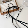 Detail of elegant black satin bow hair tie with long ribbons on a velvet jewelry tray - Black