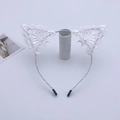Detail view of white lace cat ear headband with bell on a white display stand - White Headband