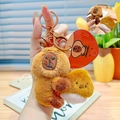 Brown Capybara plush keychain with small chestnut pendant and golden metal bell - Capybara Holding Chestnut