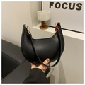 Close-up of black crescent shoulder bag with smooth leather finish and gold zipper detail - Black
