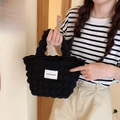 Vista dettagliata della borsa tote trapuntata nera a bolle con etichetta logo e zip - Nero