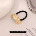 Elastic hair tie featuring a textured wavy gold metal ornament measuring 5cm x 2.1cm - Curved Stripe Gold
