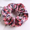 Detailed texture of fabric scrunchie with skull and pink flower pattern on white background - Skull