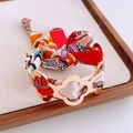 Golden clover-shaped bangle intertwined with a colorful patterned silk ribbon accessory - Gold Red Print Interwoven Bangle