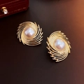 Orecchini vintage a vortice dorati con perle bianche su sfondo di pelle scura - Spirale dorata con contorno di perle (61#)