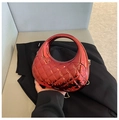 Detail of glossy metallic red handbag featuring diamond quilted pattern and round handle - Red