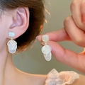 Gros plan sur d'élégantes boucles d'oreilles rondes à pampilles en nacre sur un mannequin - Style Clou d'Oreille Carré Doré avec Plaques Rondes Multicouches (4#)