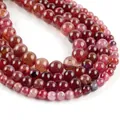 Macro shot of natural red agate round beads showing textured patterns and glossy finish - Red Dragon Veins Agate
