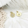 Macro shot of gold Hamsa hand and textured round charms on delicate white lace and feathers - Hamsa Hand Round Disk