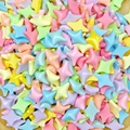 Macro shot of colorful candy-colored resin star charms for DIY nail art and jewelry - Four-Pointed Star