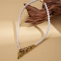 Dettaglio macro della collana di perle vintage con ciondolo a fiore e gemme colorate - Collana di perle bianche (WE6035-1)