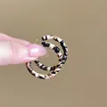 Close-up of vintage leopard print hoop earrings featuring textured fabric and metal base - Small Leopard Hoop / Black White Brown Leopard (Silver Earring Post)