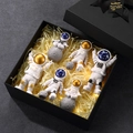 Scatola regalo nera con cinque figurine di astronauta, visiere dorate e strisce LED calde - Set Scatola Regalo da 6 Pezzi Oro e Blu