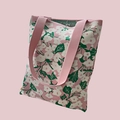 Detailed close-up of pink knit tote bag texture with white flower and green leaf patterns - Light Pink White Floral