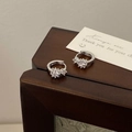 Macro-opname van zilveren S925 oorbellen met drie fonkelende zirkoniasteentjes - Grote en Kleine Zirconia-stijl / Zilver