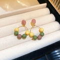 Primer plano de pendientes de cuentas de colores en una caja de joyería color beige - Estilo con Cuentas Amarillo Verde Marrón (HE20089)
