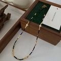 Tiger eye necklace with faceted black beads, gold accents, and white pearls on wood box - Thin Obsidian Necklace XL0474