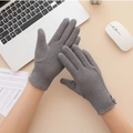 Detalle de guantes térmicos grises con puntas táctiles y diseño de pata de gallo en puño - Gris