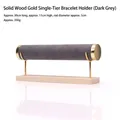 Gray velvet bracelet stand with gold metal bracket and light wood base for watch storage - Premium Grey