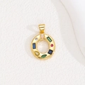 Close-up of golden round pendant with colorful cubic zirconia and vibrant gemstone inlay - Letter O