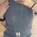 Mini-Silberkettenanhänger mit Schlangenkette getragen auf einem grauen Strickpullover - Silber Geflochtener Quadratischer Anhänger Stil (1#项链-银色-包包)