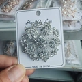 Detailed close-up of a silver floral brooch with sparkling white crystal rhinestones - Silver Snowflake Brooch