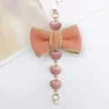 Detail of pink plush heart charms and a bow pendant with gold chain for DIY crafts - Pink