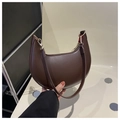 Detail view of dark brown crescent bag with smooth leather texture and gold hardware - Coffee