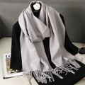 Detail shot of a soft light grey tassel scarf with elegant drape on black sweater - Lavender