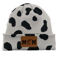 Detail of knit beanie featuring cow print pattern and MOM embossed leather patch - Dalmatian Grey/Black White Cow