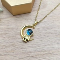 Golden crescent moon necklace featuring a small astronaut with blue galaxy textured helmet - Gold - Crescent Astronaut