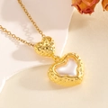 Dettaglio della collana a doppio cuore dorato con inserto in madreperla e texture martellata - Stile Doppio Cuore Madreperla Oro (T026)