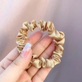 Elegant champagne gold silk satin hair scrunchie with soft pleated texture and glossy finish - Champagne