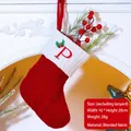 Red knit Christmas stocking with white cuff and embroidered letter P on a cozy mantel - Letter P / Red