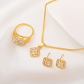 Elegantes goldfarbenes Schmuckset mit quadratischen Kristallen auf weißem Seidenhintergrund - Halskette+Ring+Ohrstecker / Gold