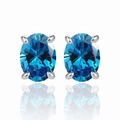 Macro detail of blue oval-cut zircon earrings with silver four-prong setting - 925 Silver / Aquamarine