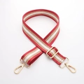 Detail eines verstellbaren, rot-gold-weiß gestreiften Canvas-Gurtes mit Metallschnallen - Gun Black Hardware / A3 Streifen Schimmer