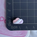 Macro shot of small pink and white heart resin accessory on a black scale ruler - Marshmallow Cloud