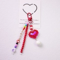 Macro view of LOVE letter beads and pixel heart pendant on colorful handmade keychain - Red