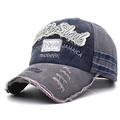 Close-up of vintage washed cotton baseball cap with 1969 embroidery and distressed edges - Navy with Grey Brim