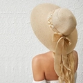 Summer wide-brim straw hat for women with bow decoration and delicate white flower accents - M (56-58cm) / Beige
