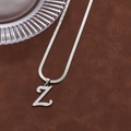 Silver hip hop initial Z pendant necklace with sleek snake chain on brown background - Letter Z