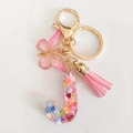Pink resin alphabet 'J' keychain with butterfly pendant, colorful heart sequins and tassel - Letter J