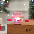 Detail of pink glowing snowman slap bracelet with LED lights on a wooden base - Sequin Glowing Snowman