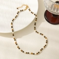 Detailed macro view of tiger eye stone beads necklace with golden lobster clasp and chain - Tiger Eye Shell Necklace