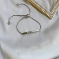 Détail du bracelet en acier argenté avec pendentif Lover Dream sur fond de soie - Argenté